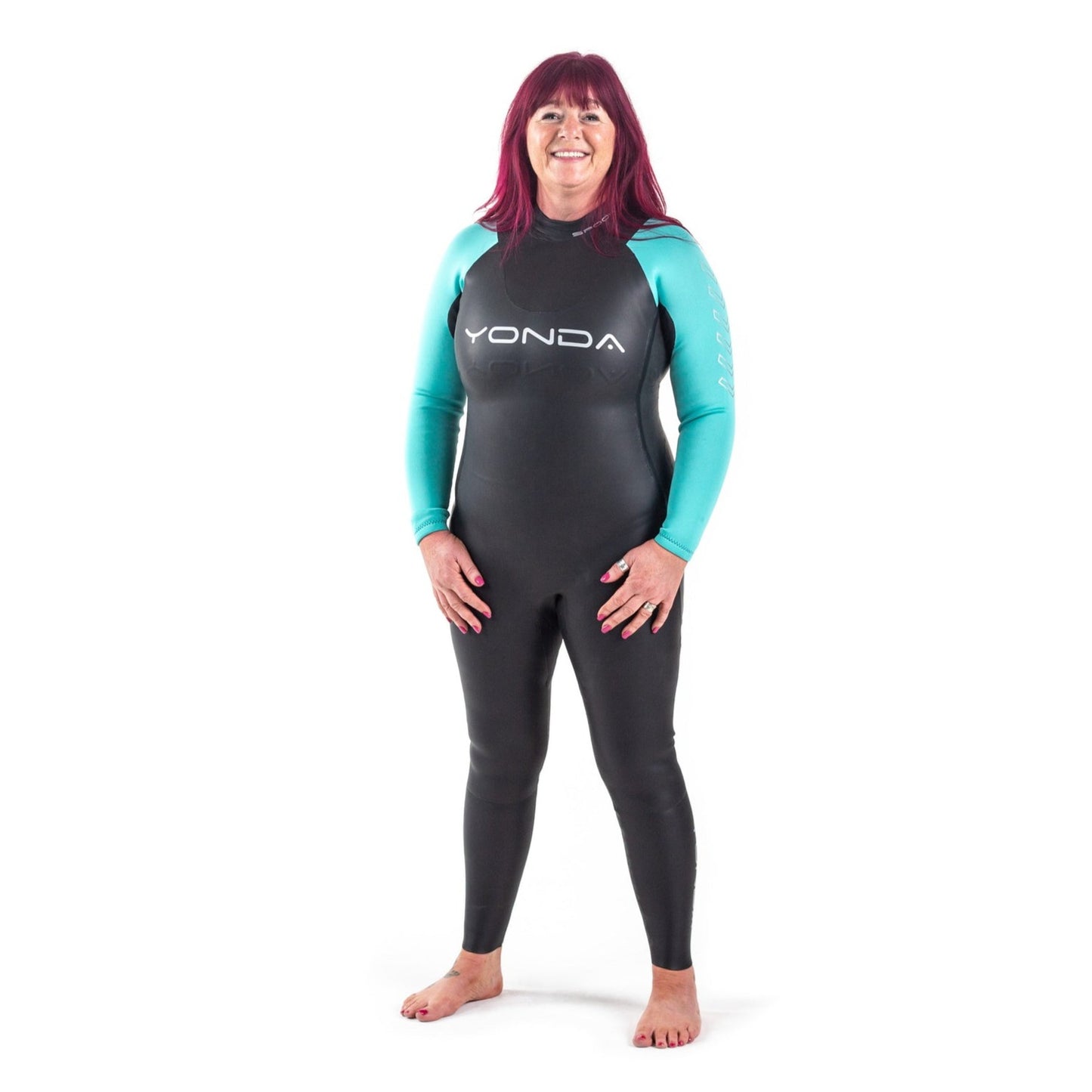 Front view of a women in a Spook Wetsuit by Yonda. A beginners Wild Swimming Wetsuit. It is black with aqua arms and the lady is smiling.