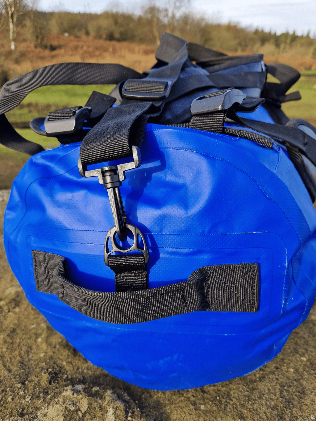 close up of the end of the blue duffel bag to show the grab handles on the waterproof swim bag