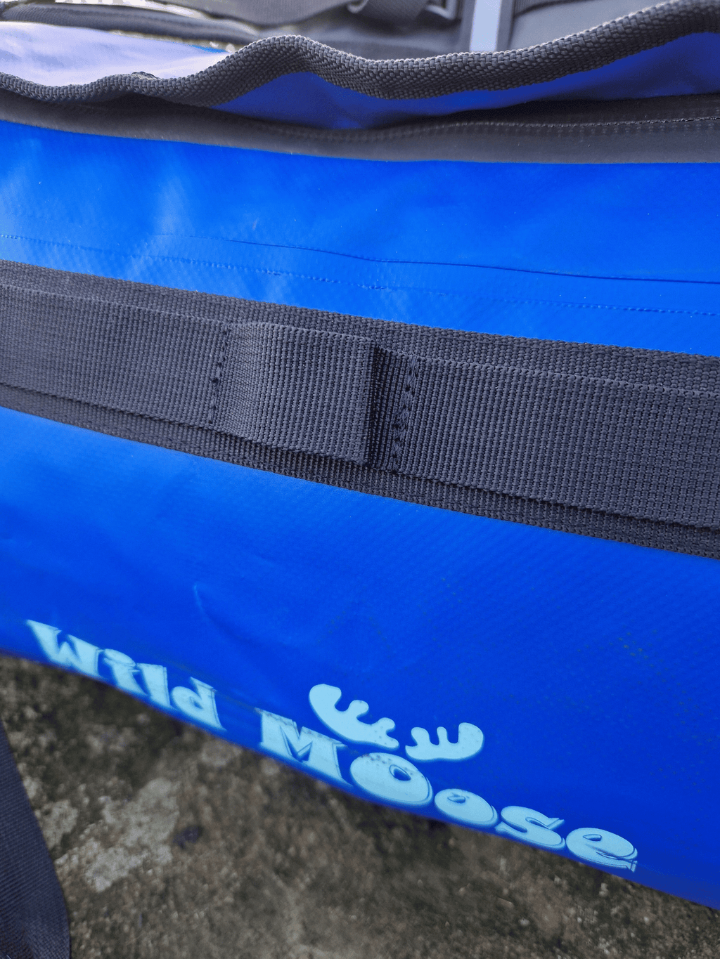 close up of a daisy chain loop on the outside of a blue waterproof bag