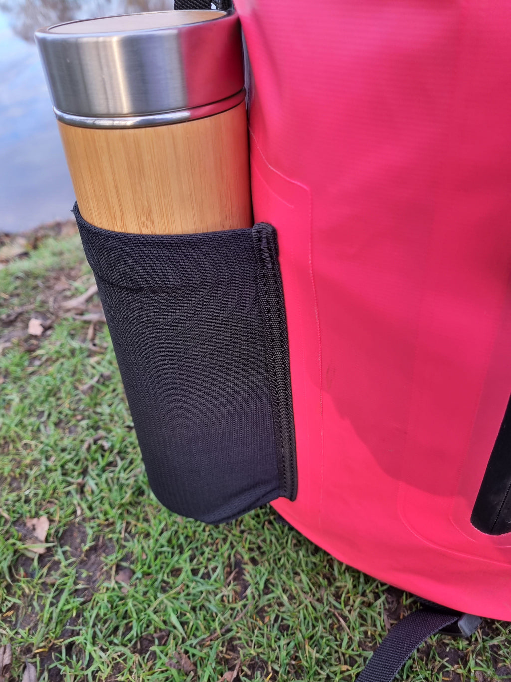 Close-up shot of a bright pink waterproof 45L backpack by Wild Moose, designed for wild swimmers, cold water swimmers, and open water adventurers.