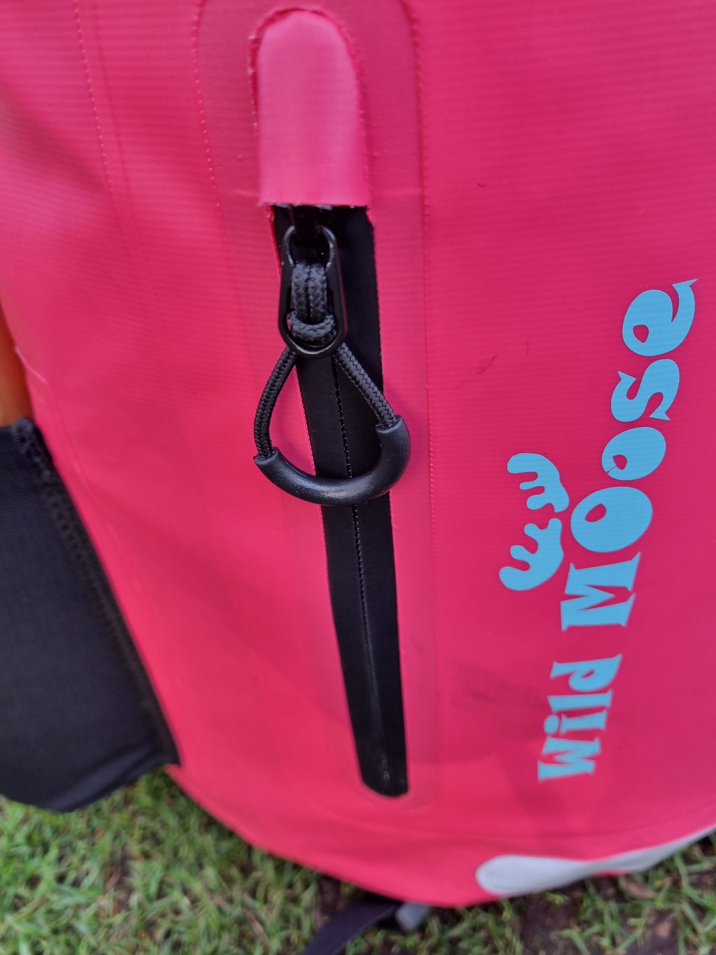 Close-up shot of a bright pink waterproof 45L backpack by Wild Moose, designed for wild swimmers, cold water swimmers, and open water adventurers.