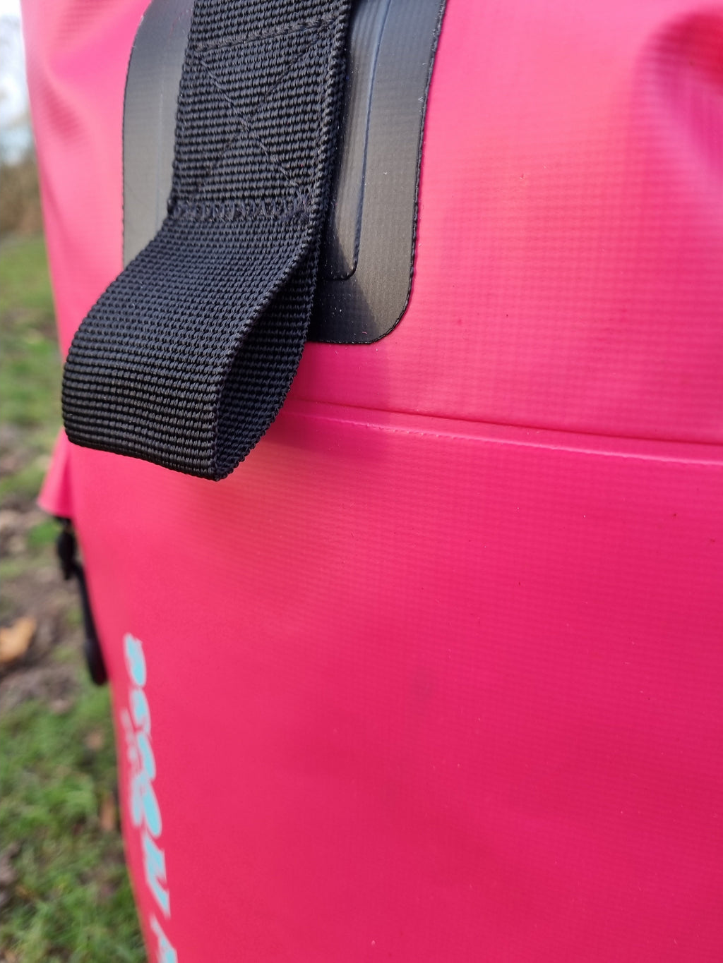 Close-up shot of a bright pink waterproof 45L backpack by Wild Moose, designed for wild swimmers, cold water swimmers, and open water adventurers.