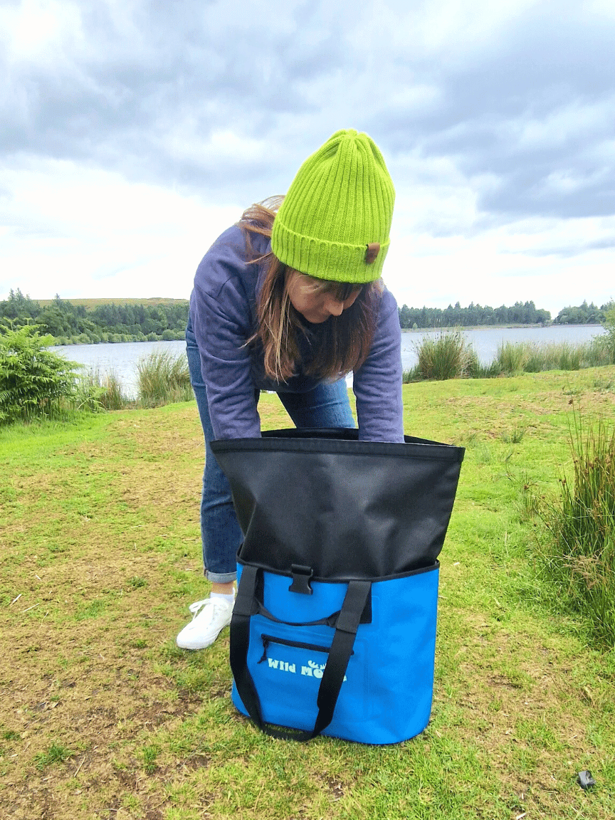 A Swimmer Looking in a Bright Blue Waterproof Swim Bag by Wild Moose ideal for Wild Swimming Swim Kit.