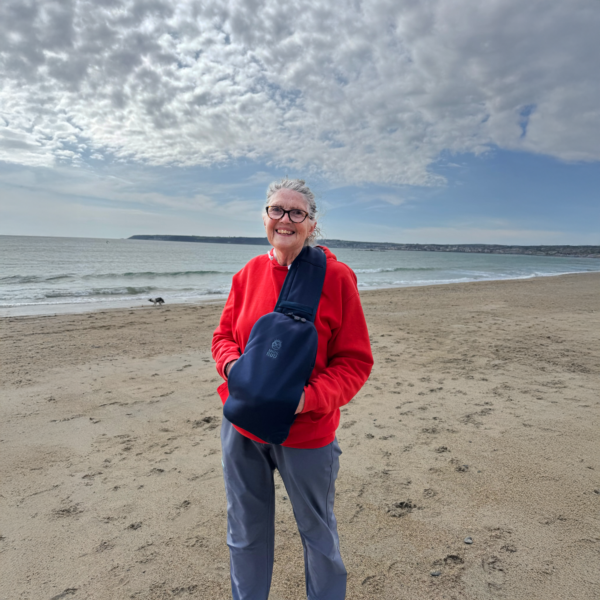 Woman wearing hot water bottle Snug Bud warm post cold water swim sea swim