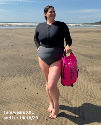 Woman wearing a Long Sleeve Swimsuit - Vivida Lifestyle XX large - XXL -  Cold water Swimming Swimsuit Thermal Neoprene - stood on the beach with a pink tow float in hand