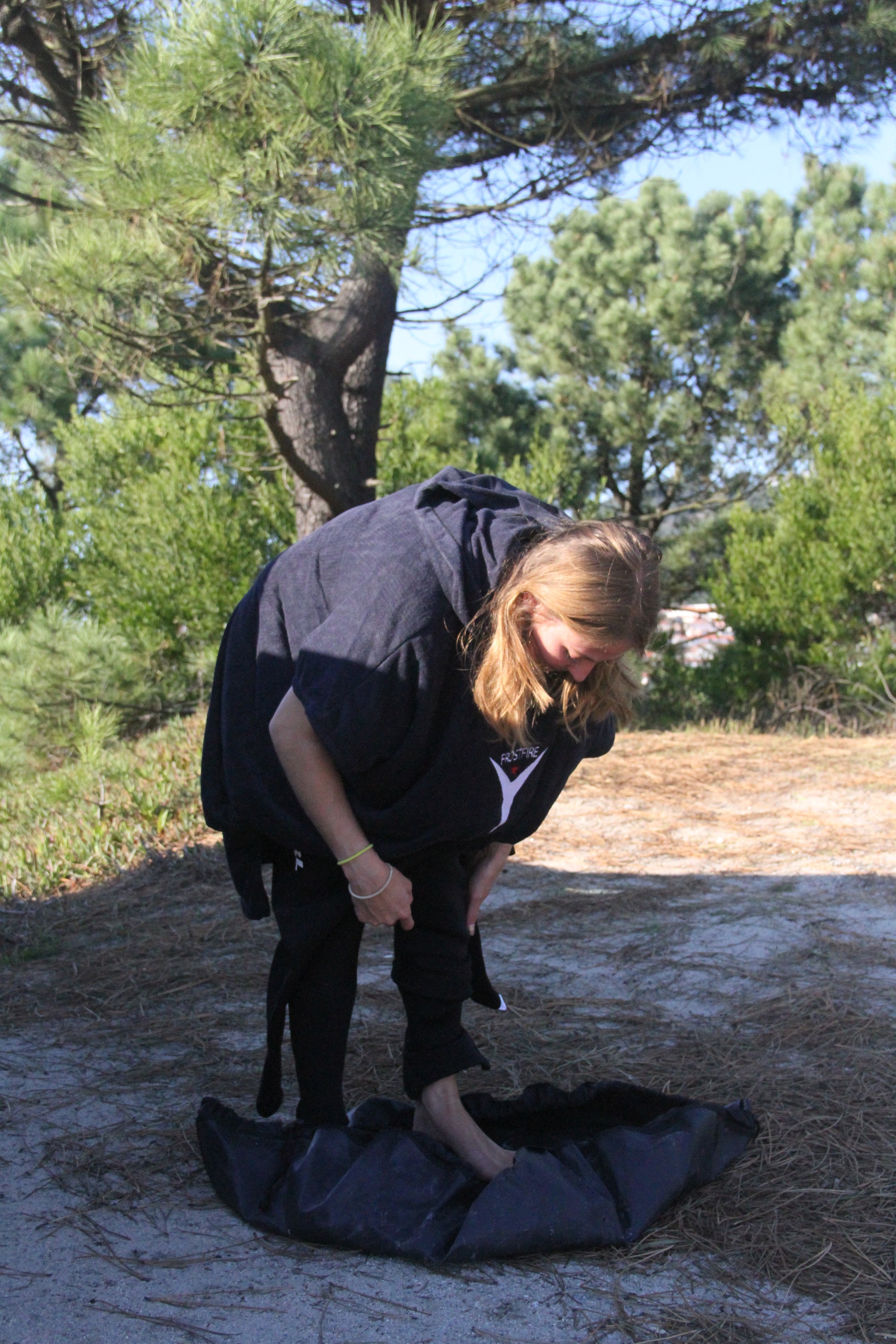 A Woman getting changed on the Frostfire - Moonbag Changing Mat and Bag for Cold Water Swimming.