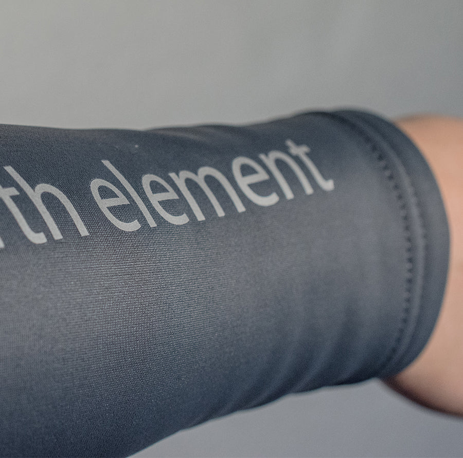 Close up of the Fourth Element name on the A woman wearing the Fourth Element - Women’s Thermocline Long Sleeve Swimsuit for Wild Swimmers